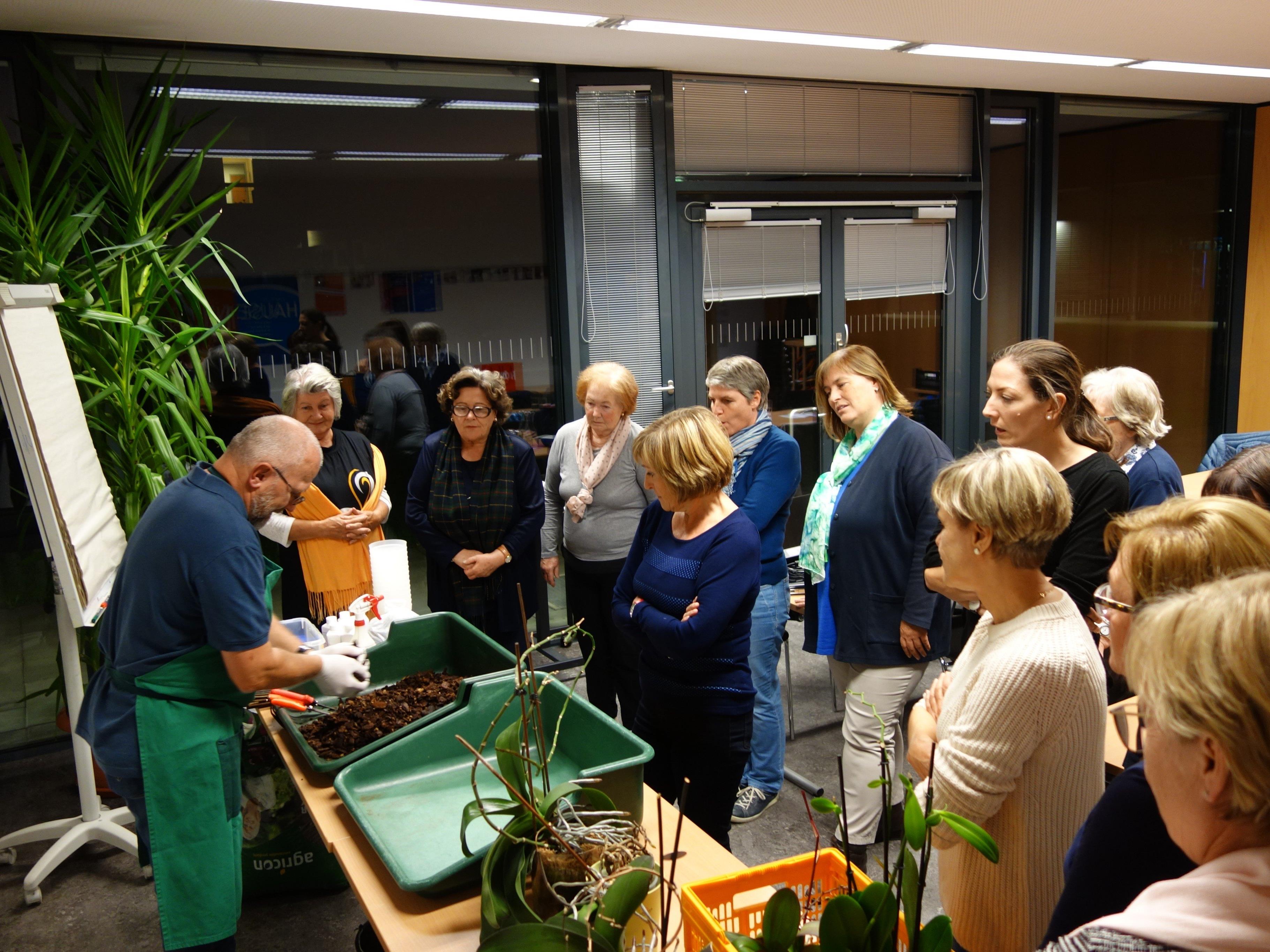 Hardy Fussenegger und die GUTA Teilnehmerinnen beim Umtopfen von Orchideen