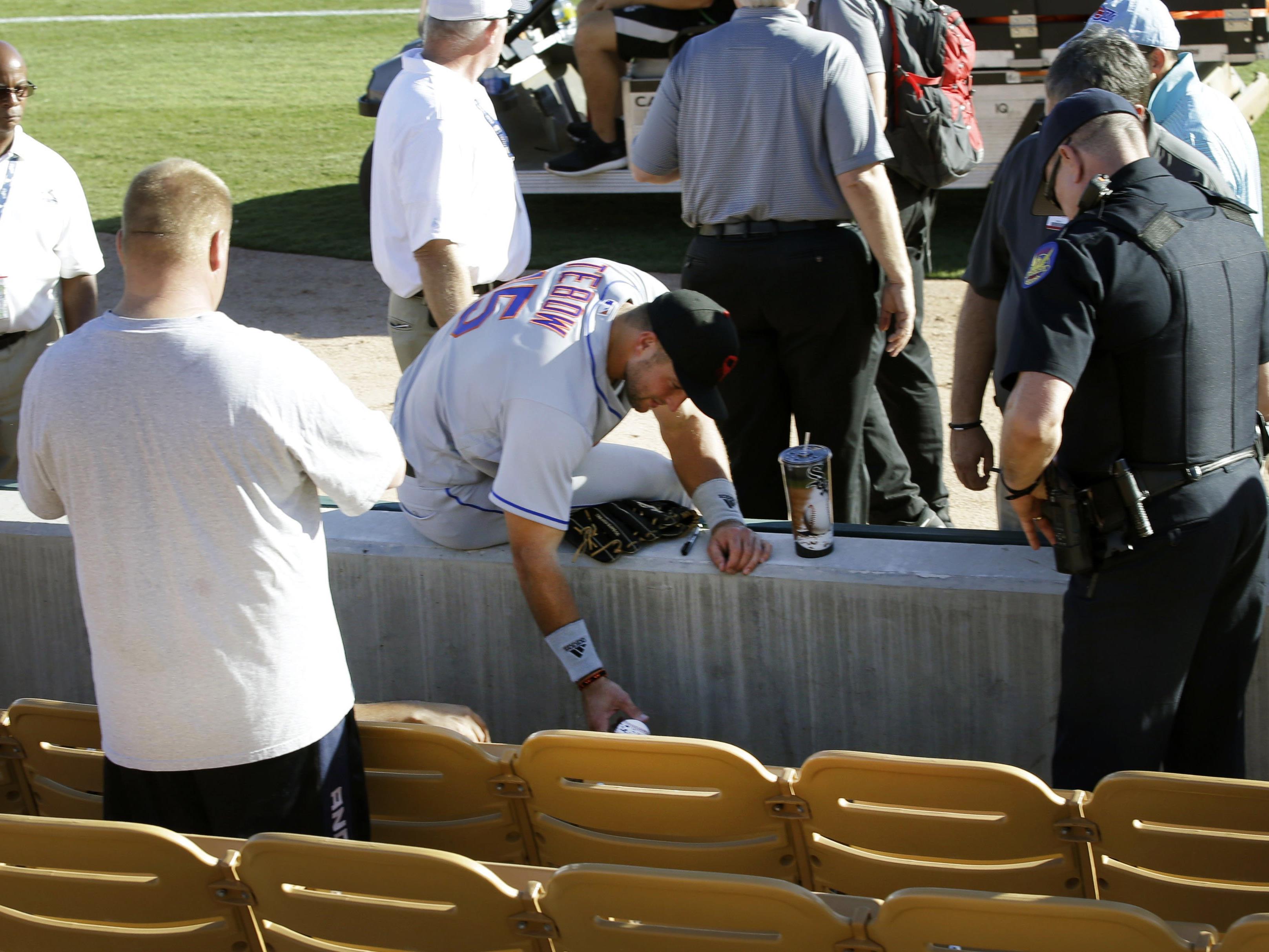 US-Sportler Tim Tebow (Mitte) kümmerte sich bei einem Baseball-Spiel um einen zusammengebrochenen Fan.