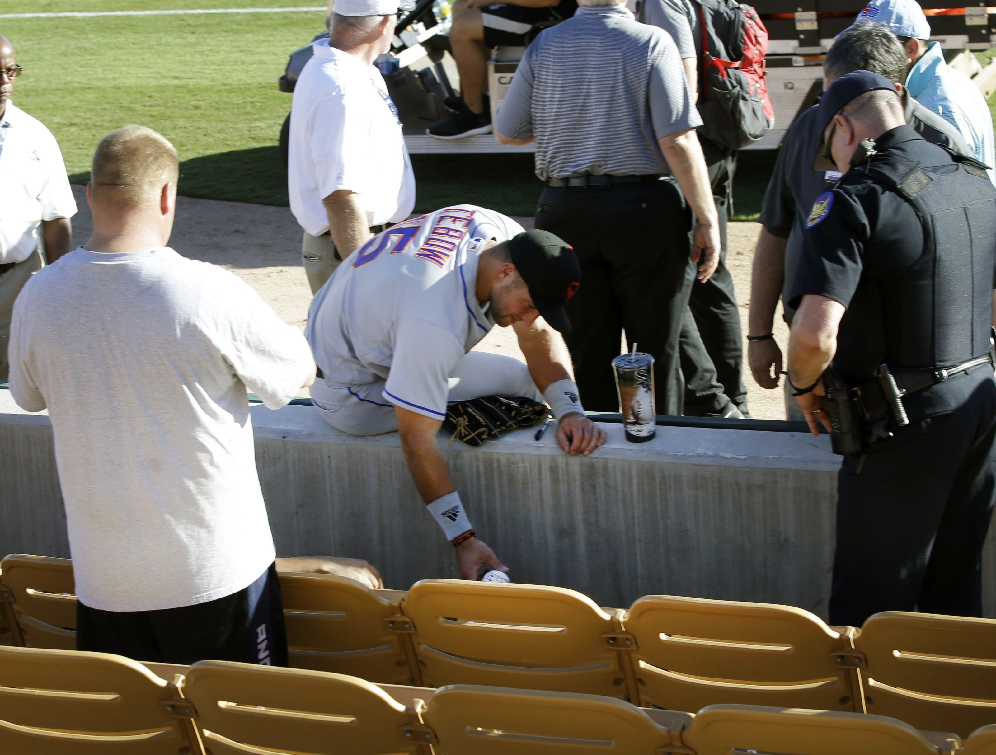 US-Sportler Tim Tebow (Mitte) kümmerte sich bei einem Baseball-Spiel um einen zusammengebrochenen Fan. US-Sportler Tim Tebow (Mitte) kümmerte sich bei einem Baseball-Spiel um einen zusammengebrochenen Fan.