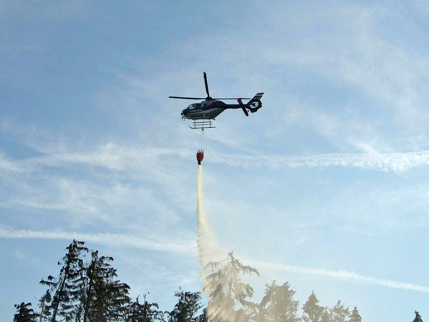 Die Feuerwehr transportiert Löschwasser mit dem Hubschrauber zu einem brennenden Ferienhaus in der Nähe der Gschwendalpe.