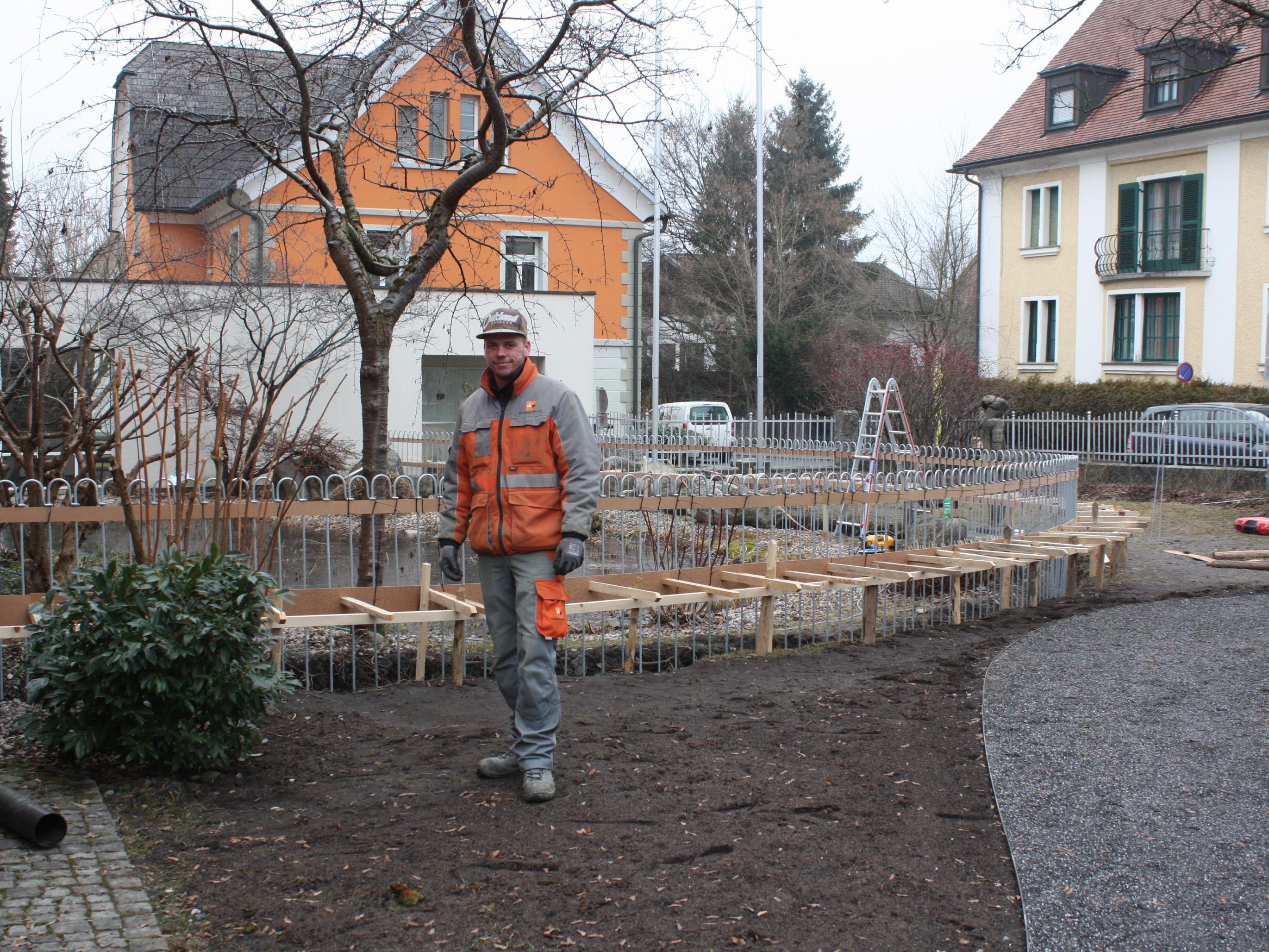 Die Gemeindearbeiter sind derzeit damit beschäftigt, einen Zaun um den Teich beim Rathaus zu errichten.