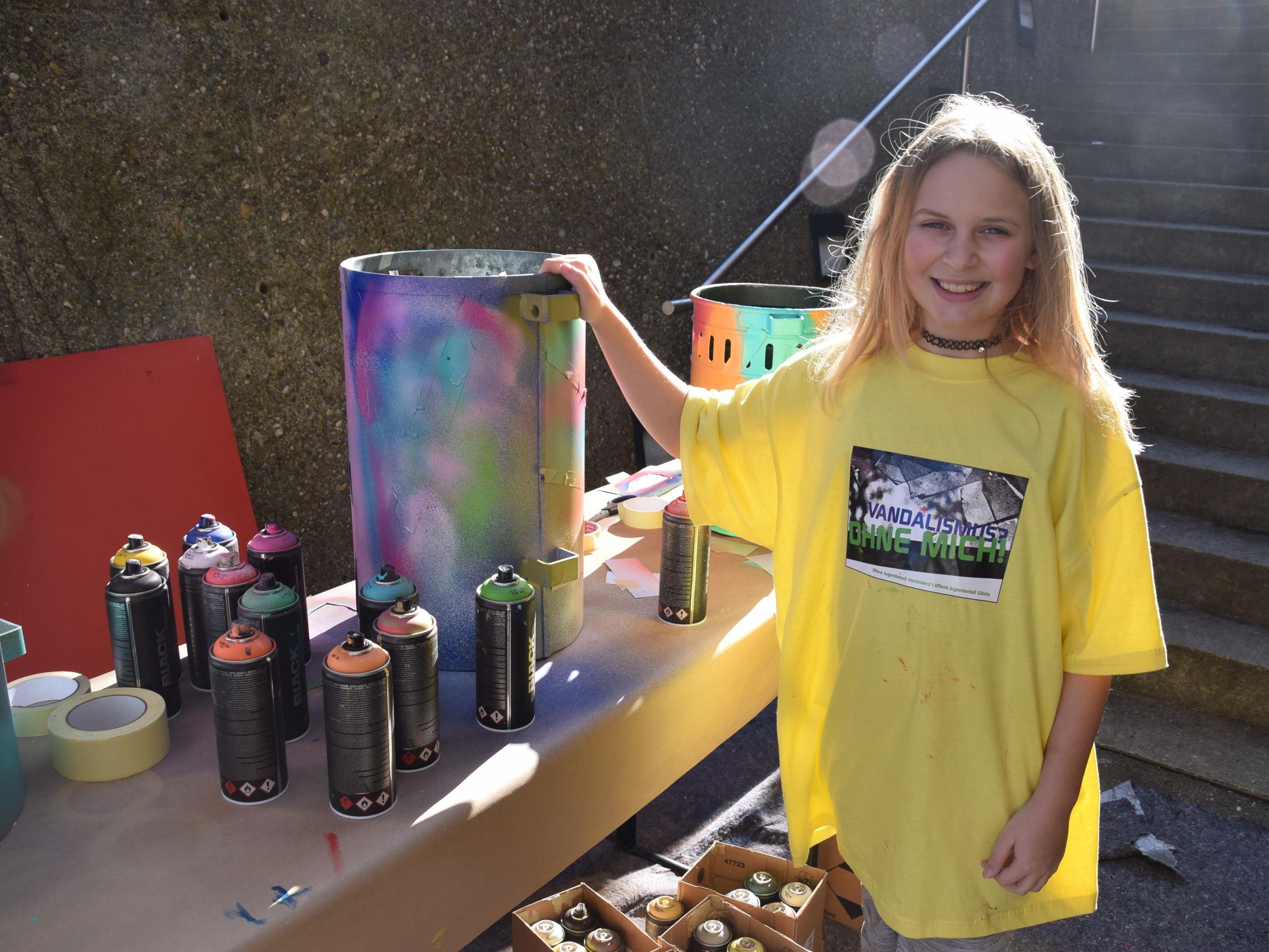Anna-Lena gestaltete die Mülleimer für die Gemeinde mit bunten Farben