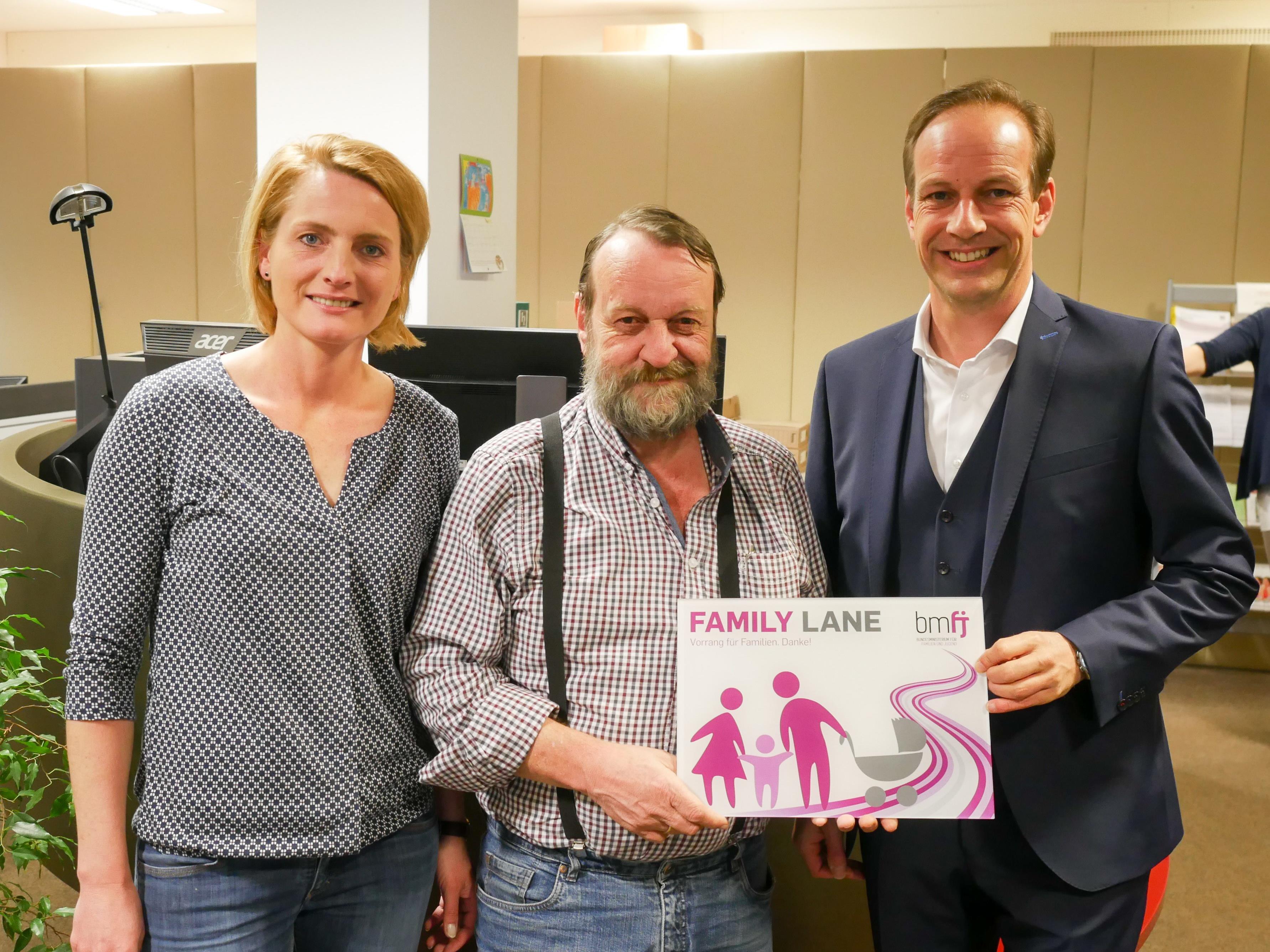 Familienstadträtin Angelika Benzer, der Leiter des Bürgerservice Egon Berchtold und Bürgermeister Dieter Egger präsentieren das Schild für die „Family Lane“