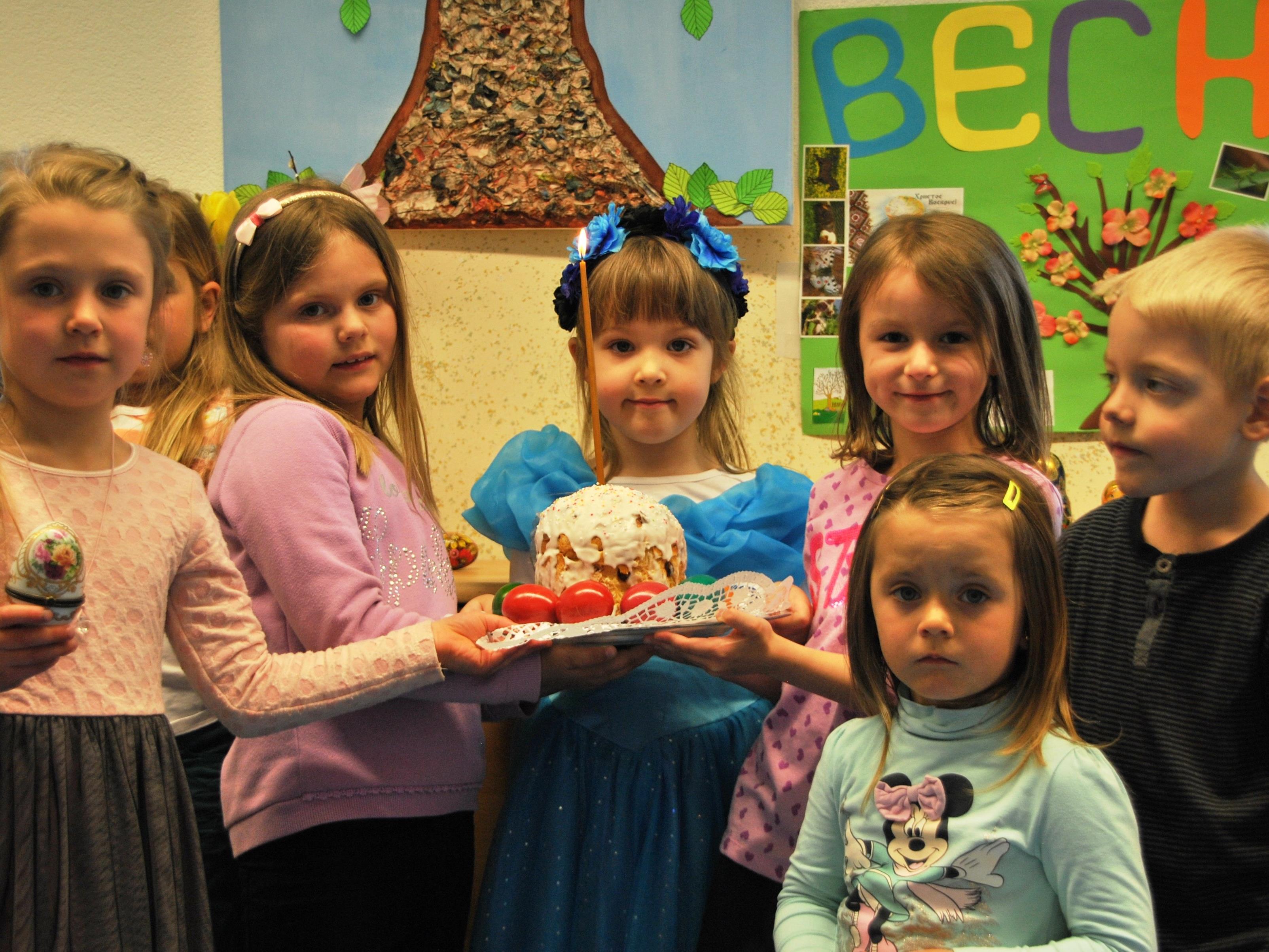 Kinder vom russischen Kinderclub mit dem Osterkuchen.