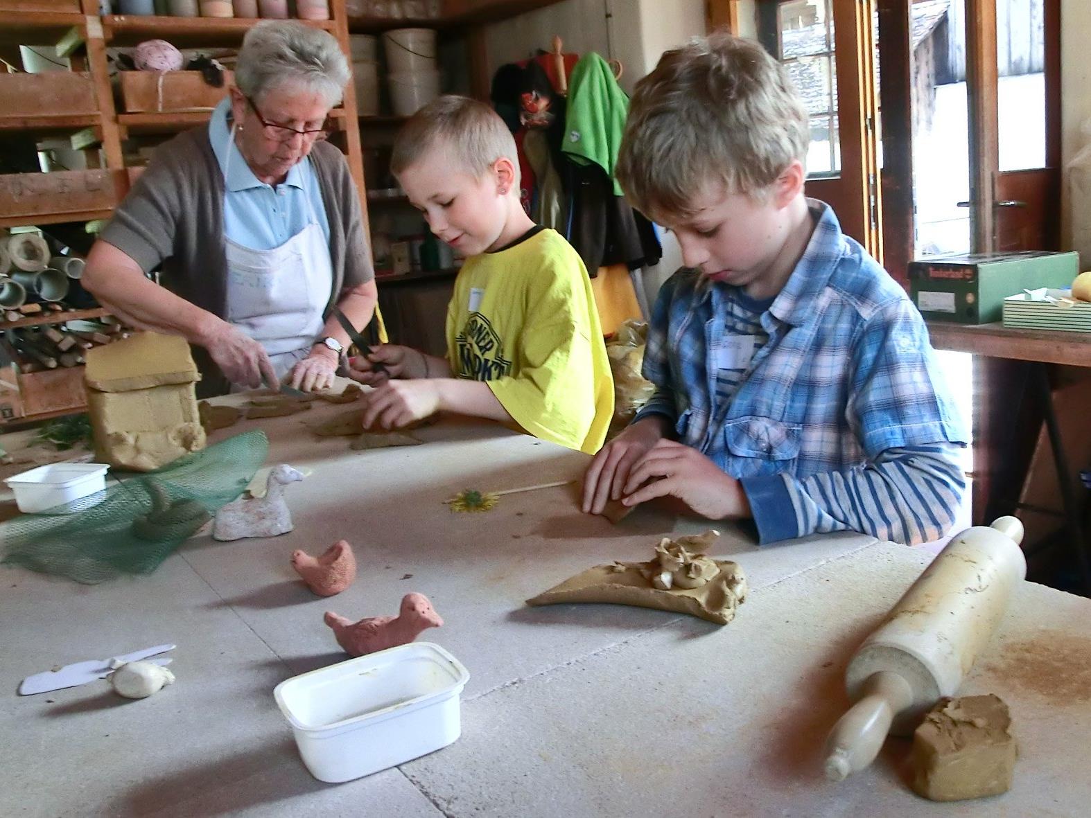 Kinder beim Modellieren von kleinen Kunstwerken aus Ton im Schlosserhus.