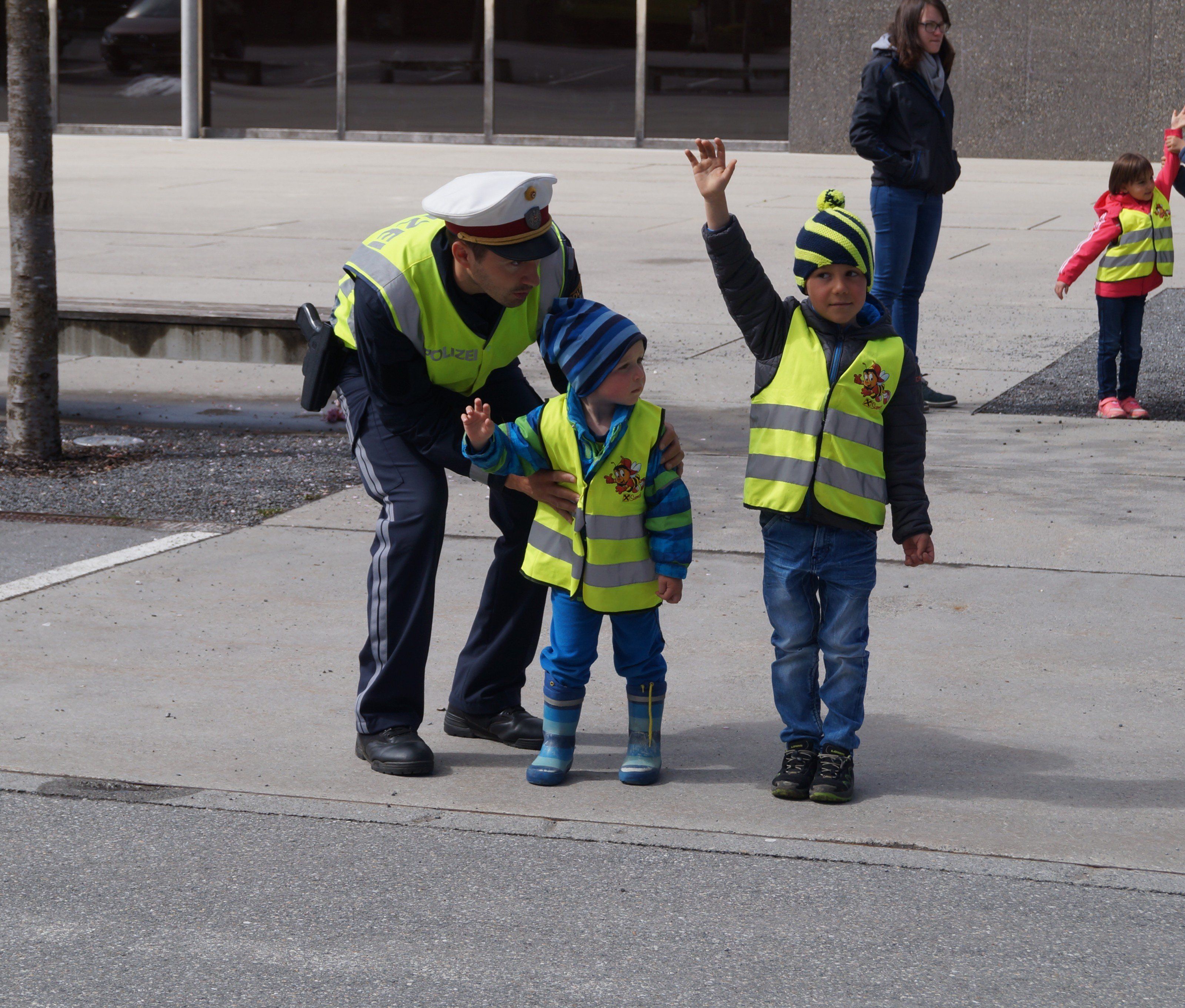 Draußen auf der Straße übte der Polizist mit den Kindern das richtige Überqueren der Straße und wies dabei auf Gefahren und schwierige Situationen hin. Draußen auf der Straße übte der Polizist mit den Kindern das richtige Überqueren der Straße und wies dabei auf Gefahren und schwierige Situationen hin.