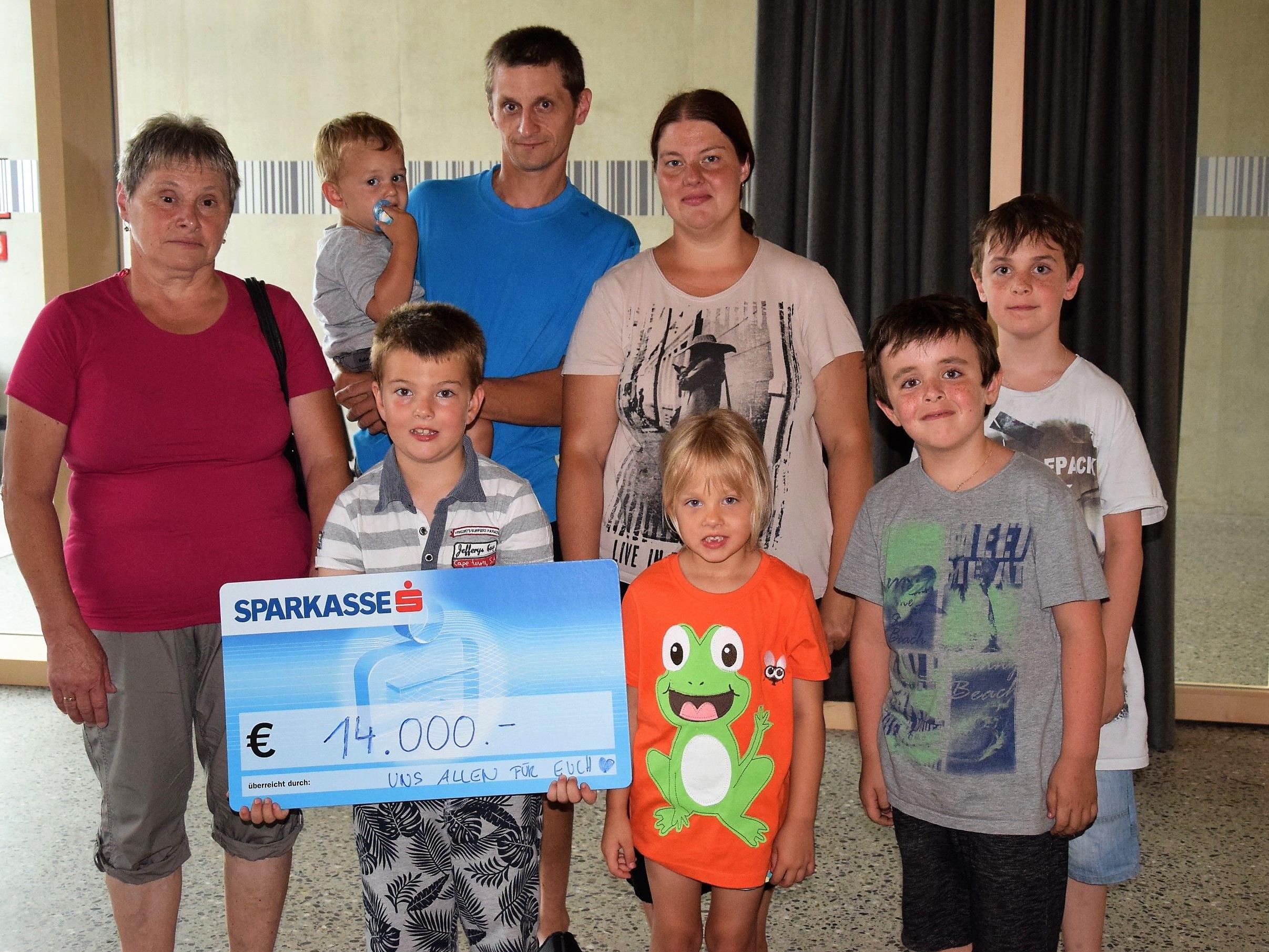 Fabian und Daniel Lampert (rechts) übergaben stellvertretend für die Organisatoren der Familie Kathan einen Scheck über 14 000.- Euro für einen Neuanfang