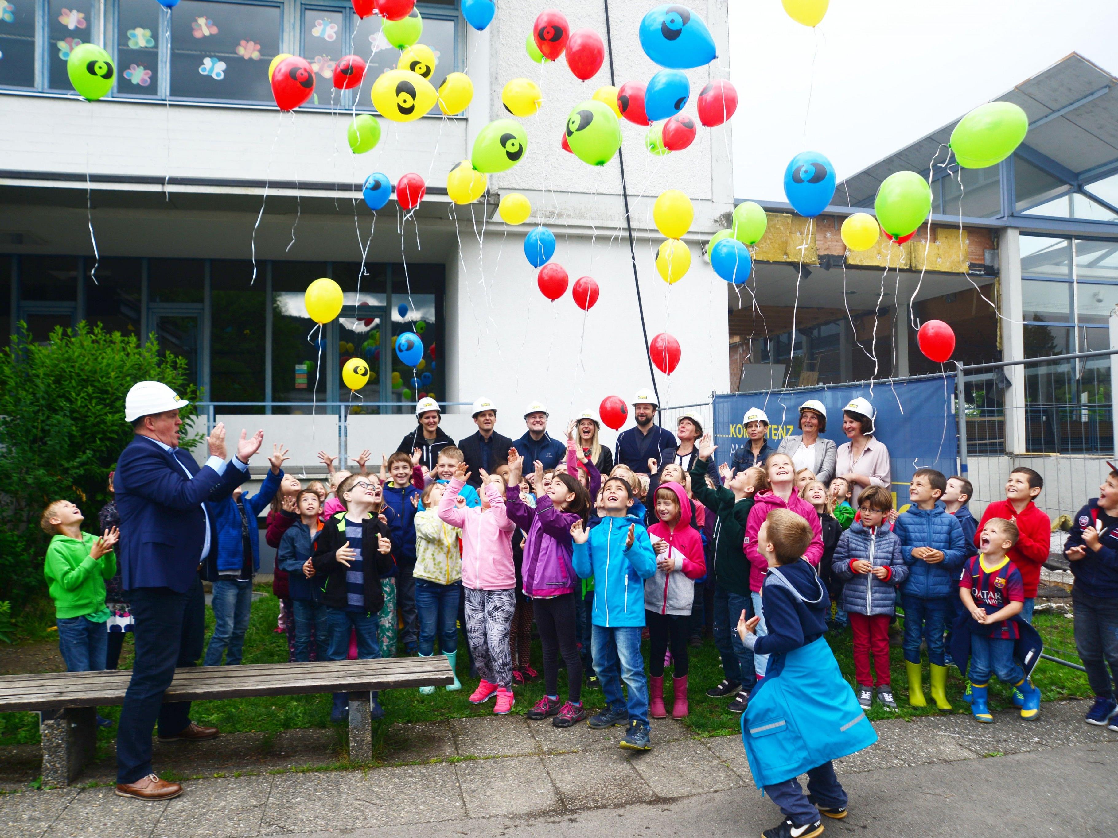 Kinder entließen beim Spatenstich bunte Luftballons in den Himmel.