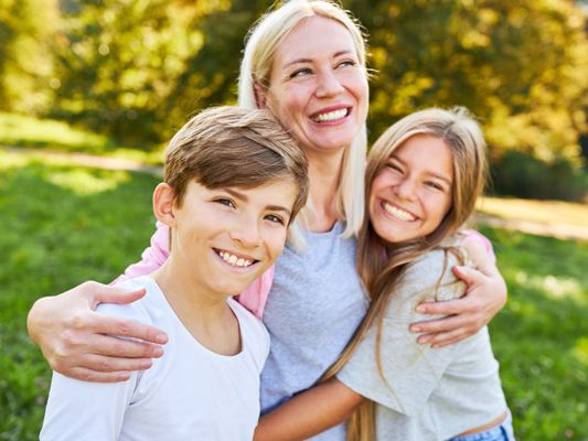 Glückliche Mutter umarmt liebevoll ihre Kinder. Glückliche Mutter umarmt liebevoll ihre Kinder.